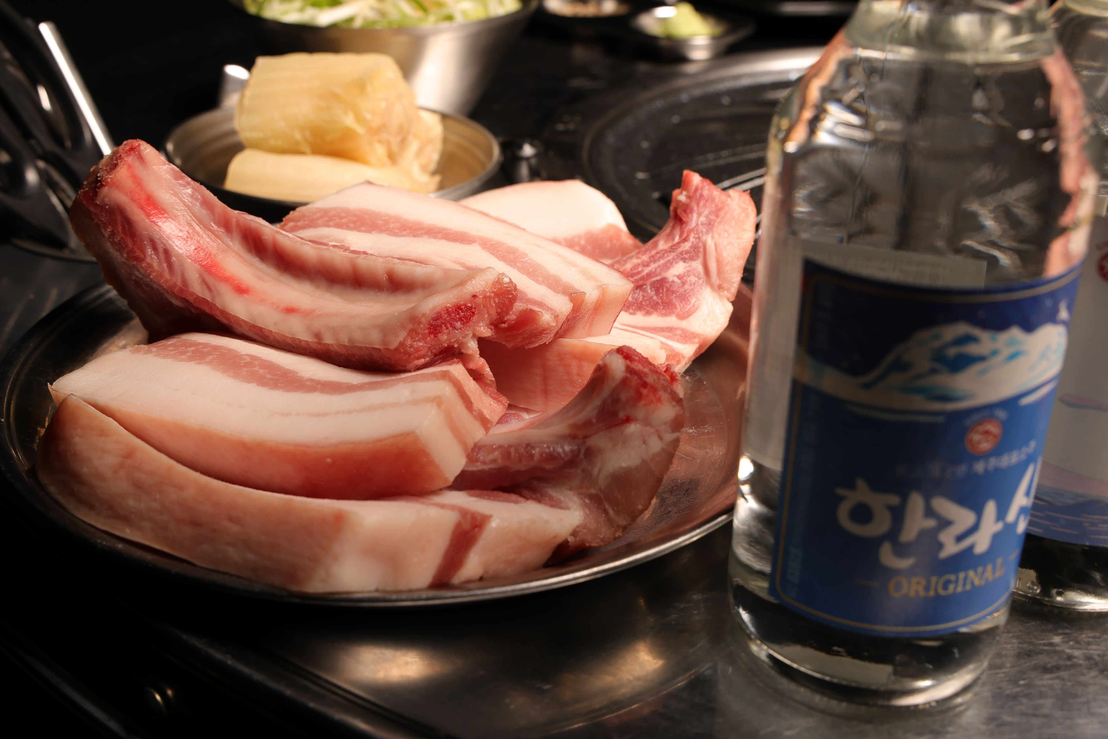 돗갈비 원육과 한라산 소주가 놓인 상차림